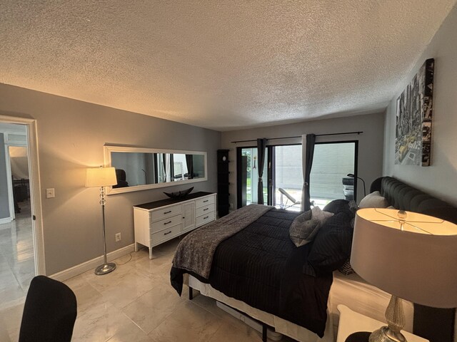 1705 Presidential Way N Unit B101, West Palm Beach, FL 33401 - bedroom featuring access to outside, a textured ceiling, baseboards, and light marble finish floors