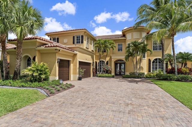 3454 Lago De Talavera, Lake Worth, FL 33467 - mediterranean / spanish home featuring french doors, decorative driveway, stucco siding, a front lawn, and an attached garage