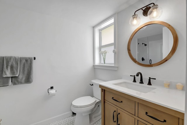 bathroom featuring toilet, vanity, and baseboards