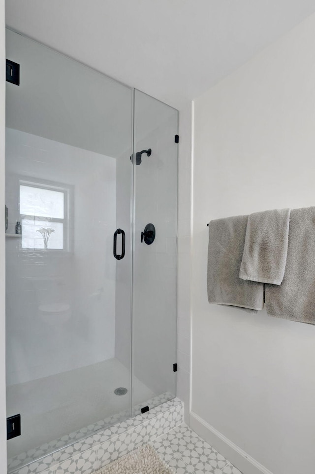 full bathroom featuring a stall shower and baseboards