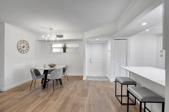 dining room with baseboards, light wood-style floors, crown molding, and visible vents
