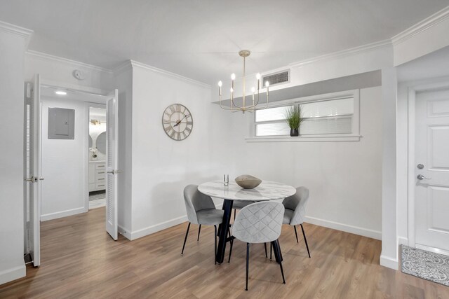 dining space with visible vents, baseboards, ornamental molding, and wood finished floors
