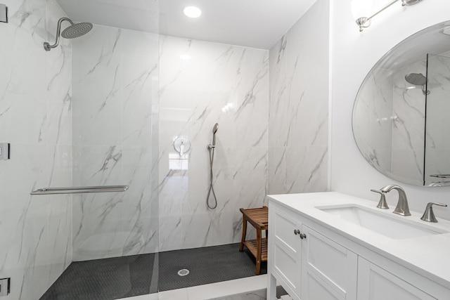 full bath featuring a marble finish shower and vanity