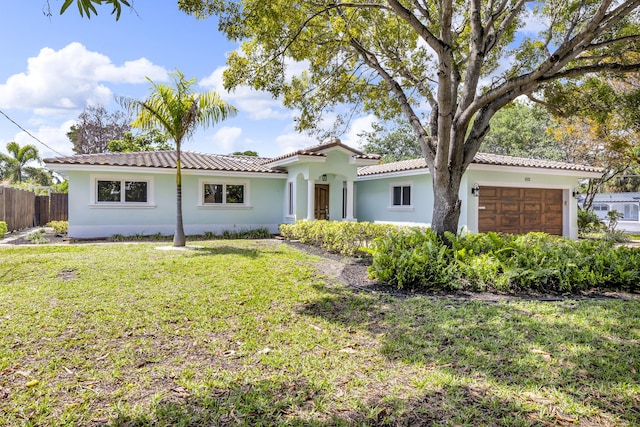 view of front of house with fence, a garage, stucco siding, a tile roof, and a front yard