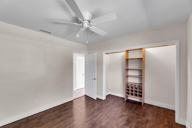 unfurnished bedroom with a closet, visible vents, wood finished floors, and baseboards