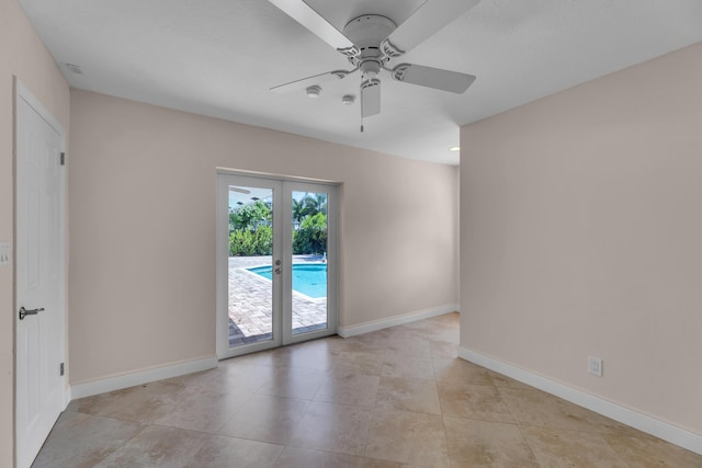 unfurnished room with light tile patterned flooring, baseboards, and a ceiling fan