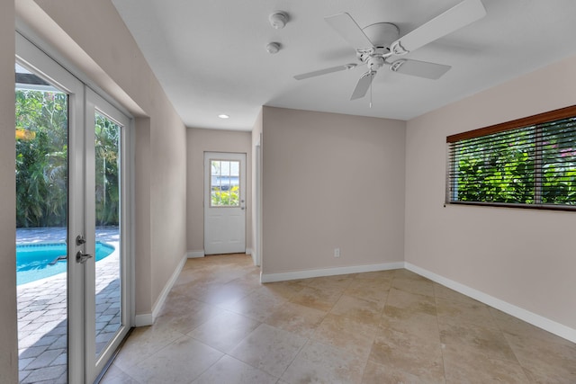 empty room with french doors, recessed lighting, a ceiling fan, light tile patterned floors, and baseboards
