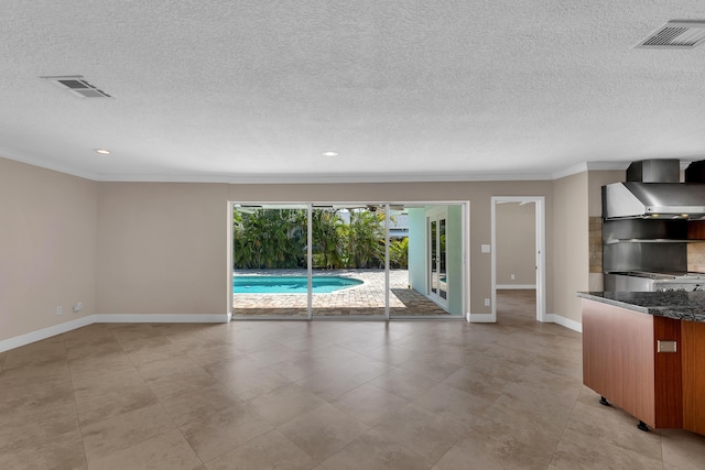 unfurnished living room featuring baseboards, ornamental molding, visible vents, and a textured ceiling