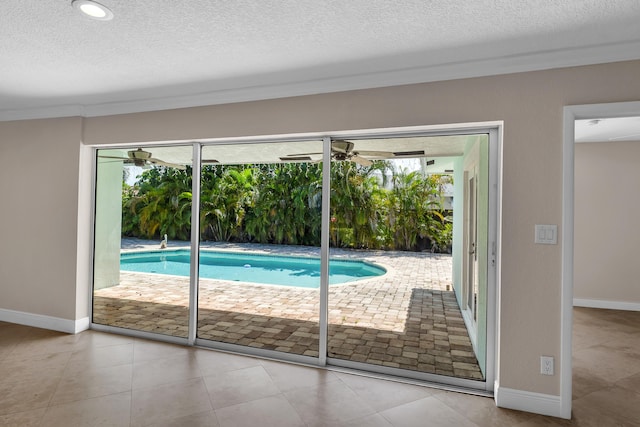 doorway to outside featuring baseboards, a wealth of natural light, and a textured ceiling