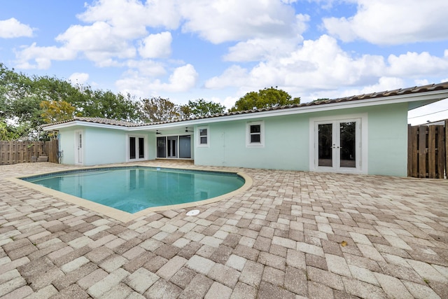 view of pool featuring a patio, french doors, fence, ceiling fan, and a fenced in pool