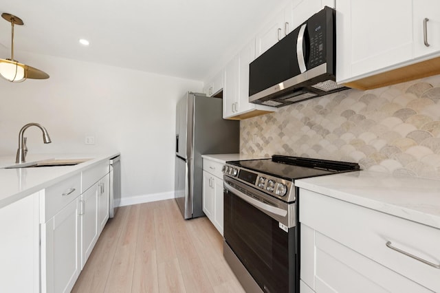 6201 62nd Way, West Palm Beach, FL 33409 - kitchen with stainless steel appliances, a sink, decorative backsplash, light wood-style floors, and white cabinetry