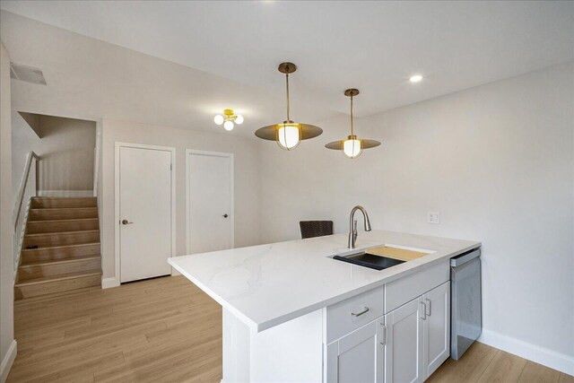 6201 62nd Way, West Palm Beach, FL 33409 - kitchen with a sink, light wood-type flooring, baseboards, hanging light fixtures, and stainless steel dishwasher
