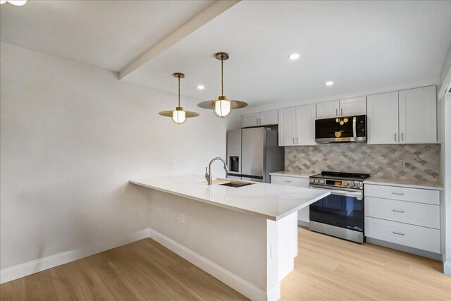 6201 62nd Way, West Palm Beach, FL 33409 - kitchen featuring appliances with stainless steel finishes, a sink, baseboards, decorative backsplash, and light wood finished floors