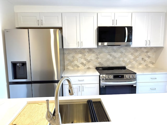 6201 62nd Way, West Palm Beach, FL 33409 - kitchen with stainless steel appliances, light countertops, white cabinets, decorative backsplash, and a sink