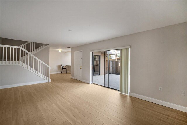 6201 62nd Way, West Palm Beach, FL 33409 - empty room with wood finished floors, baseboards, and stairs