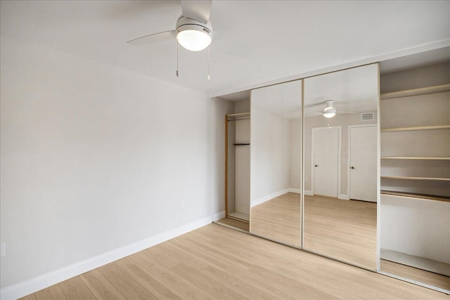6201 62nd Way, West Palm Beach, FL 33409 - unfurnished bedroom featuring wood finished floors, baseboards, a ceiling fan, and a closet
