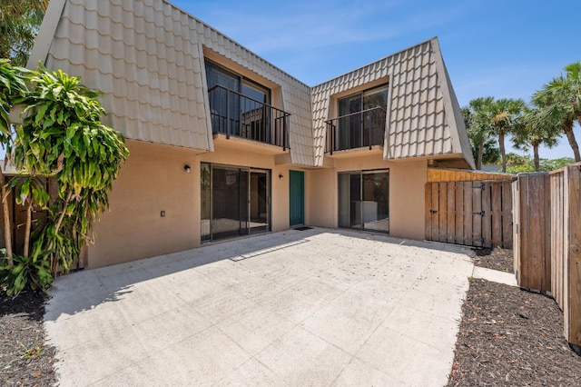 6201 62nd Way, West Palm Beach, FL 33409 - rear view of house with mansard roof, stucco siding, a patio, and a tile roof