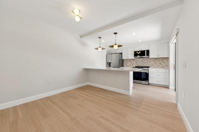 6201 62nd Way, West Palm Beach, FL 33409 - kitchen with appliances with stainless steel finishes, a peninsula, tasteful backsplash, white cabinets, and light countertops