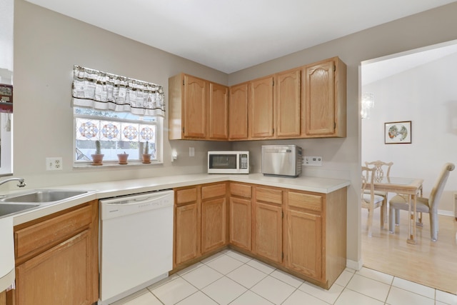 kitchen with light countertops, light tile patterned floors, a sink, and white appliances