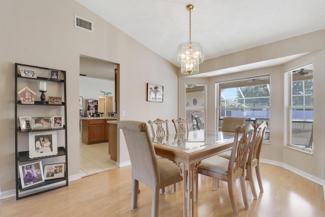 dining area with baseboards, visible vents, a chandelier, and light wood finished floors