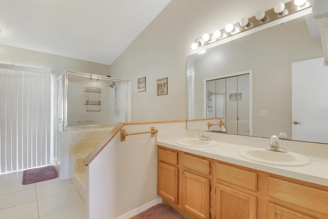 full bathroom with double vanity, lofted ceiling, a stall shower, and a sink