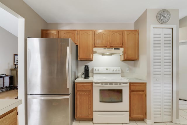 kitchen featuring light countertops, freestanding refrigerator, electric stove, and under cabinet range hood