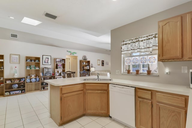 kitchen with dishwasher, visible vents, light tile patterned floors, a sink, and a peninsula