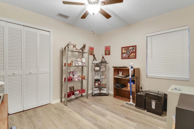 office space featuring wood finished floors, visible vents, a textured ceiling, and ceiling fan