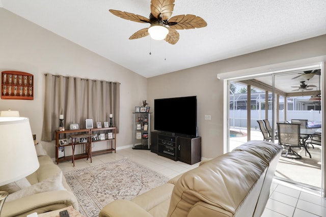 living room featuring ceiling fan, vaulted ceiling, and light tile patterned floors