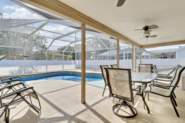 view of pool with glass enclosure, a fenced backyard, a fenced in pool, a patio, and ceiling fan