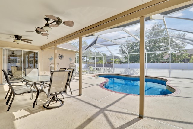 view of swimming pool with glass enclosure, a ceiling fan, a fenced backyard, a patio, and a fenced in pool