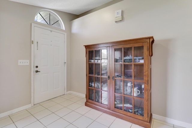 entrance foyer featuring baseboards and light tile patterned floors