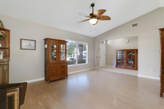 living room featuring vaulted ceiling, a ceiling fan, light wood-type flooring, baseboards, and visible vents