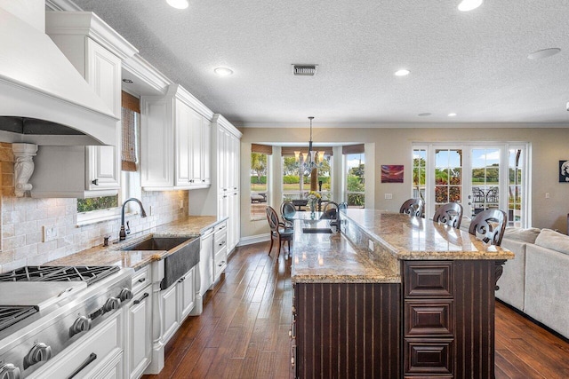 21281 Waycross Dr, Boca Raton, FL 33428 - kitchen with stainless steel gas cooktop, custom exhaust hood, ornamental molding, a sink, and light stone countertops