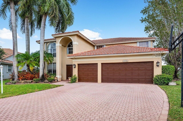 21281 Waycross Dr, Boca Raton, FL 33428 - mediterranean / spanish house with stucco siding, decorative driveway, an attached garage, and a tiled roof