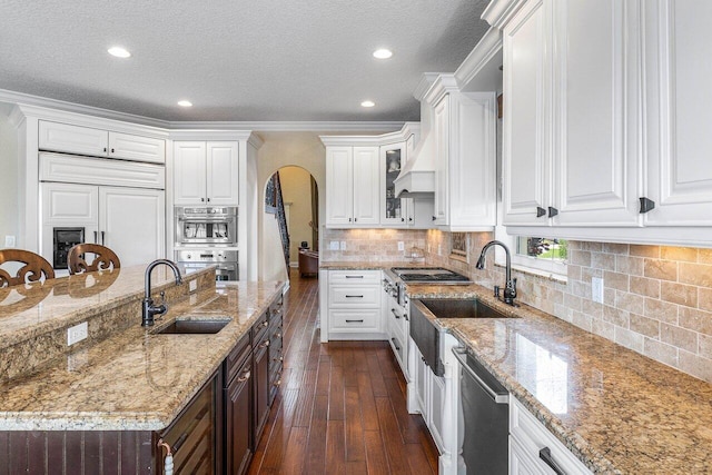 21281 Waycross Dr, Boca Raton, FL 33428 - kitchen featuring stainless steel appliances, a sink, arched walkways, dark wood-type flooring, and white cabinets