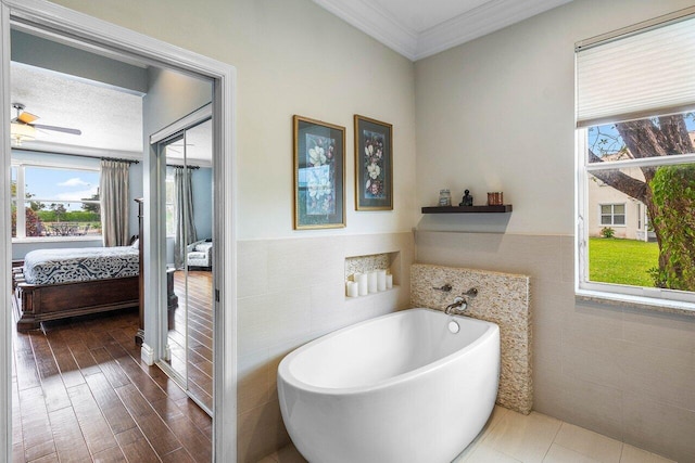 21281 Waycross Dr, Boca Raton, FL 33428 - bathroom with connected bathroom, tile walls, a freestanding bath, ornamental molding, and ceiling fan