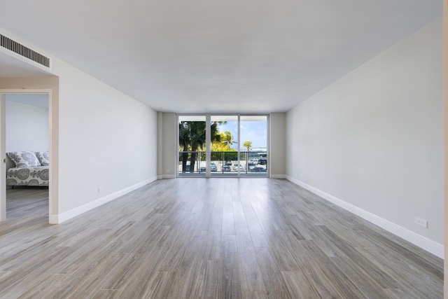 2800 N Flagler Dr Unit 207, West Palm Beach, FL 33407 - spare room with wood finished floors, visible vents, baseboards, and a wall of windows