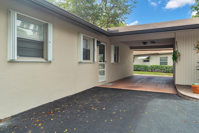155 Mockingbird Ln, Delray Beach, FL 33445 - view of property exterior featuring a carport and stucco siding
