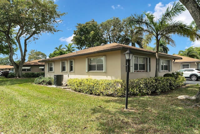 155 Mockingbird Ln, Delray Beach, FL 33445 - view of front of home featuring cooling unit, stucco siding, and a front lawn