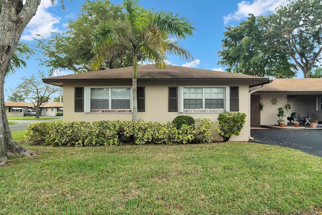 155 Mockingbird Ln, Delray Beach, FL 33445 - view of front of property with a shingled roof, stucco siding, and a front lawn