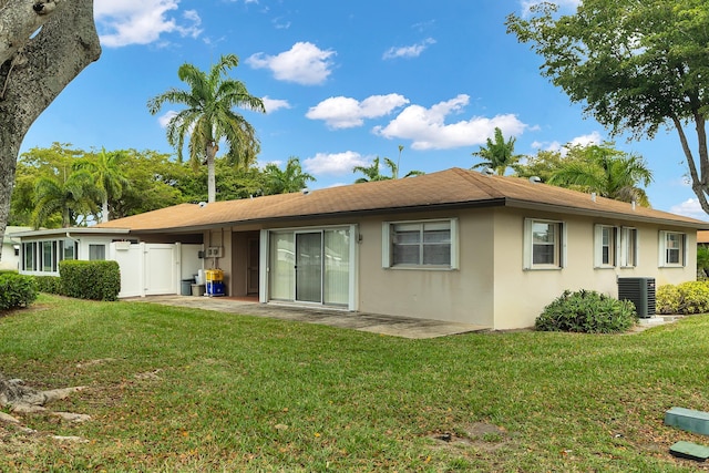 155 Mockingbird Ln, Delray Beach, FL 33445 - back of house with central air condition unit, a patio, a lawn, and stucco siding
