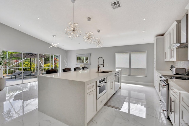 kitchen with visible vents, marble finish floor, light countertops, a sink, and stainless steel appliances