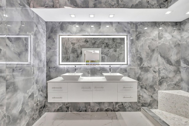 bathroom featuring double vanity, tile walls, and a sink
