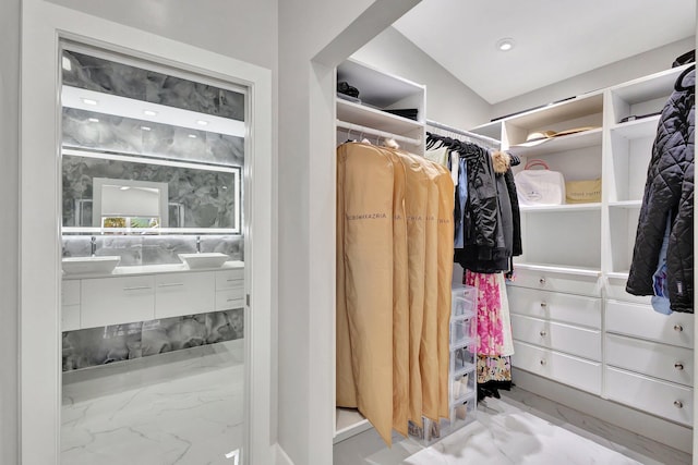 walk in closet featuring a sink and marble finish floor