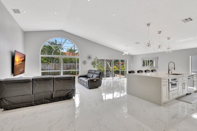 living area with marble finish floor, visible vents, a notable chandelier, and plenty of natural light