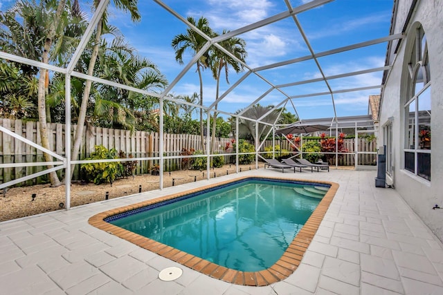 view of swimming pool with a patio area, a fenced backyard, glass enclosure, and a fenced in pool