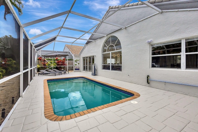 outdoor pool featuring a patio area and glass enclosure