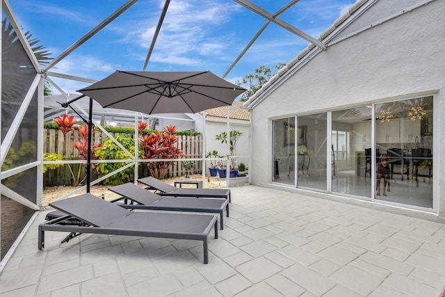 view of patio / terrace with a lanai and fence