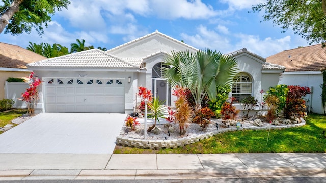 view of front of home with a garage, driveway, stucco siding, and a tile roof